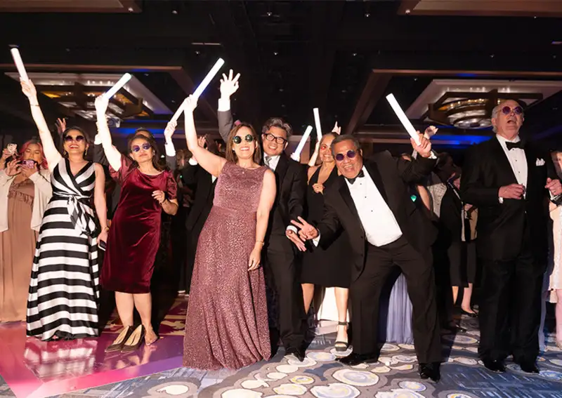 Event Guests dancing to RAIN and celebrating at the Annual Scholarship Gala themed Come Together